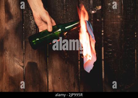 Molotow-Cocktail in den Händen eines Mädchens, Kriegsrecht in der Ukraine, ein Mädchen, das sich bereit macht, ihr Haus zu verteidigen, brennbares Gemisch in Flaschen mit einem Lappen, Stockfoto