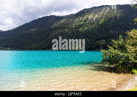 Wunderschönes türkisfarbenes sauberes Wasser am Weissensee in Kärnten, Österreich Stockfoto