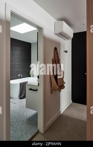 Begehbarer Kleiderschrank und eigenes Bad im Hauptschlafzimmer. Birchgrove House, Sydney, Australien. Architekt: TW Architects, 2021. Stockfoto