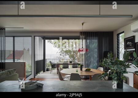 Essbereich und Außenterrasse mit Blick von der Küche. Birchgrove House, Sydney, Australien. Architekt: TW Architects, 2021. Stockfoto