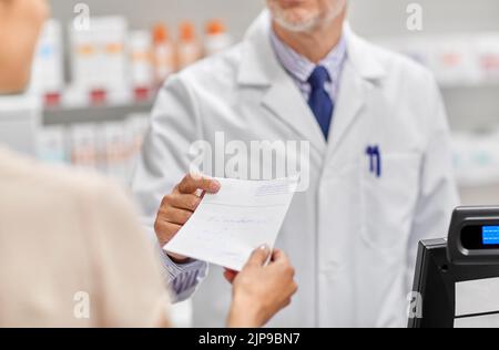 Apotheker und Kunde mit ärztlicher Verschreibung Stockfoto