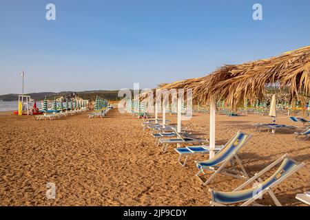 Leere Sonnenliegen bei Sonnenaufgang in Scialara, einem sandigen Sonnenaufgangsstrand Gargano, Italien Stockfoto