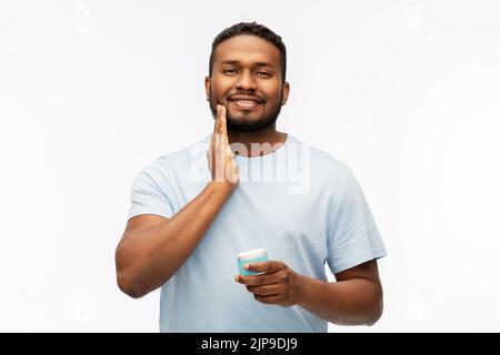 Glücklicher afrikanischer Mann, der Wachs auf seinen Bart aufgetragen hat Stockfoto