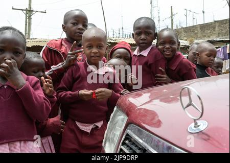 KENIA, Nairobi, Mathare Slum, Kontrastschulkinder und gebrauchte Mercedes Benz Autos aus Europa / KENIA, Nairobi, Stadtteil Mathare, Slum, Kontrast Schulkinder und gebrauchter Mercedes Benz aus Europa Stockfoto