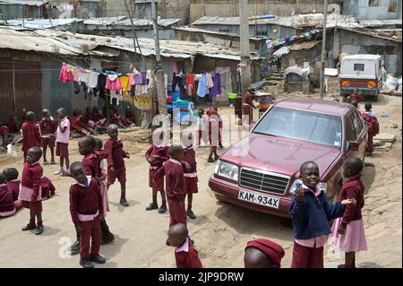 KENIA, Nairobi, Mathare Slum, Kontrastschulkinder und gebrauchte Mercedes Benz Autos aus Europa / KENIA, Nairobi, Stadtteil Mathare, Slum, Kontrast Schulkinder und gebrauchter Mercedes Benz aus Europa Stockfoto