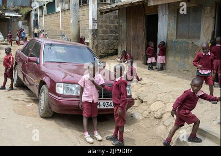 KENIA, Nairobi, Mathare Slum, Kontrastschulkinder und gebrauchte Mercedes Benz Autos aus Europa / KENIA, Nairobi, Stadtteil Mathare, Slum, Kontrast Schulkinder und gebrauchter Mercedes Benz aus Europa Stockfoto