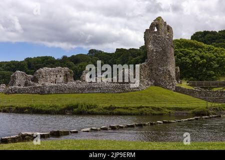 Die Ruinen von Ogmore Castle, mit Trittsteinen über dem Fluss Ewny, Glamorgan, Südwales Stockfoto