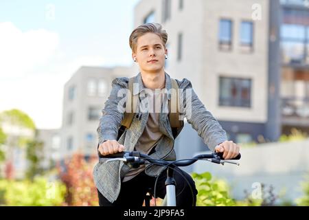Student Junge mit Tasche und Kopfhörer Fahrrad fahren Stockfoto