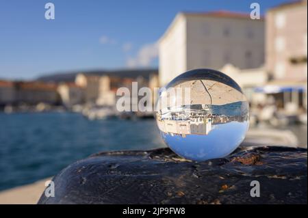 Glaskugel auf einem rostigen Poller, Hafen von Cres (Kroatien), sonniger Tag im Frühling Stockfoto