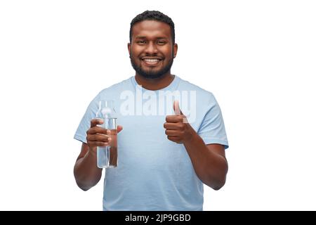 Glücklicher afrikanischer Mann mit Wasser in Glasflasche Stockfoto