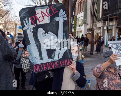 Eine ältere Frau hält ein Friedenszeichen, um während eines marsches in Tokio, Japan, gegen den Ukraine-Russland-Krieg zu protestieren. Stockfoto