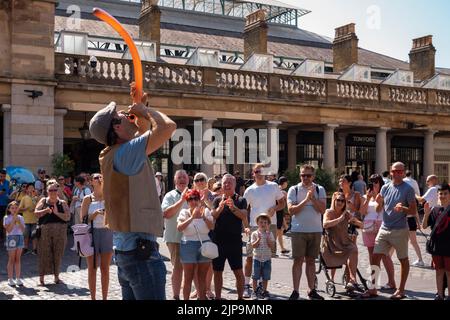 Street Entertainer tritt vor Touristen in Covent Garden, London, Großbritannien, auf Stockfoto
