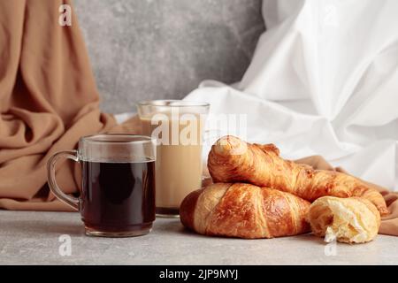 Frisch gebackene Croissants und Kaffee auf einem Küchentisch. Stockfoto