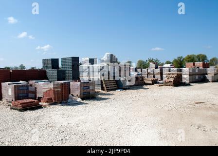 Gestapelte Paletten mit Baumaterialien auf einer Baustelle Stockfoto