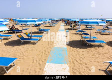 Traditionelle Strandliege und Sonnenschirm. Rimini, Italien, Stockfoto