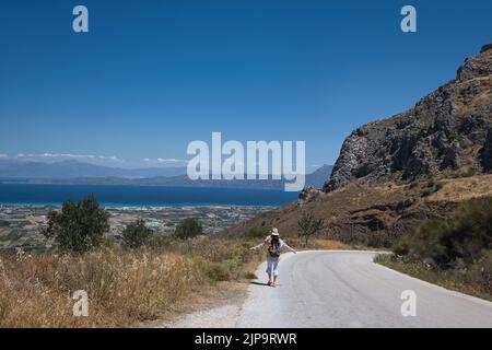 Frau Tourist zu Fuß den Hügel in Richtung Korinth von der historischen Stätte Acrocorinth, Griechenland im Sommer Stockfoto