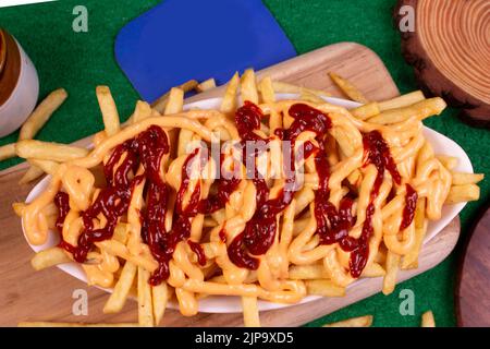 Gericht mit KITSCHIGEN POMMES im Café-Restaurant. Amerikanisches Fast-Food-Gericht, bestehend aus pommes Frites mit Käse. Stockfoto