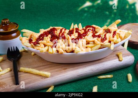 Gericht mit KITSCHIGEN POMMES im Café-Restaurant. Amerikanisches Fast-Food-Gericht, bestehend aus pommes Frites mit Käse. Stockfoto