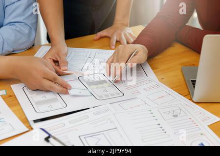 UX UI Konzept, Grafikdesigner arbeiten mit UX UI Designer zusammen, die Application Template Layout Framework für mobile Telefoncomputer planen Stockfoto