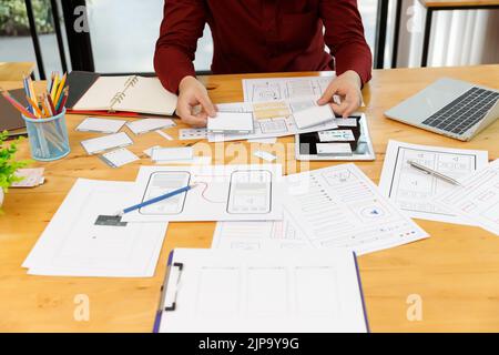 UX UI Konzept, Grafikdesigner arbeiten mit UX UI Designer zusammen, die Application Template Layout Framework für mobile Telefoncomputer planen Stockfoto