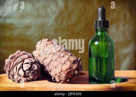Grüne Flasche mit natürlichem ätherischem Öl und Pipette auf dem Display. Pflanzliche Kosmetika und Cremes Stockfoto