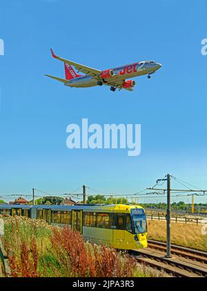 Die Straßenbahn Manchester Metrolink nähert sich der Haltestelle Manchester Airport, Manchester, England. Stockfoto