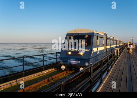 Der alte Diesel-Zug der Southend Pier Railway wurde wieder in Betrieb genommen, während Probleme mit neuen Elektrozügen behoben wurden. Menschen, die auf Gehwegen gehen. Abend Stockfoto