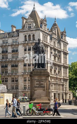 London, Großbritannien - 4. Juli 2022: Entlang Whitehall A3212, Bronzestatue von Spencer Compton, 8. Herzog von Devonshire auf beigefarbenem Steinsockel vor dem Alten Krieg Stockfoto