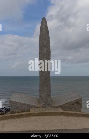 Eine vertikale Aufnahme des Pointe du Hoc Ranger Monument aus dem Zweiten Weltkrieg mit Wasser im Hintergrund Stockfoto