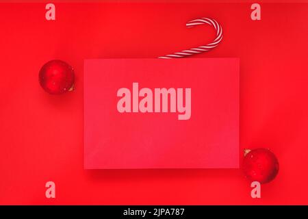 Leerer roter Hintergrund und leeres Weihnachtspapier mit roten Kugeln auf rotem Hintergrund. Minimalkonzept. Werbevorlage. Draufsicht, Platz für te Stockfoto