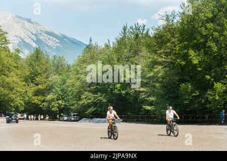 Pescasseroli, Italien - die Menschen genießen einen sonnigen Tag, um den Start des Wanderweges neben dem Berg zu erreichen Stockfoto