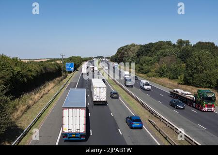 dh Traffic A1M AUTOBAHN YORKSHIRE Britische dreispurige Lkw transportieren Autos auf stark frequentierten Autobahnen großbritanniens Stockfoto