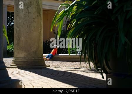 Schwerin, Deutschland - Juli 17. 2022: Ein Junge erfrischt sich an einem heißen Tag beim Spielen an einem alten Brunnen im Schloss Schwerin Stockfoto