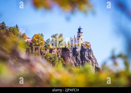 Split Rock Lighthouse in Minnesota, eingerahmt von Herbstblättern. Stockfoto