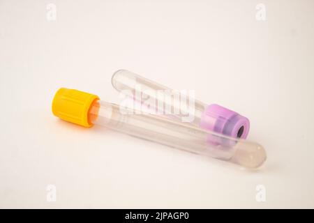 Gelbe, violett gefärbte Blutteströhrchen auf dem isolierten weißen Hintergrund Stockfoto
