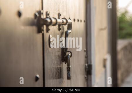 Alte Holztüren mit Ringen und altmodischer Klopfgriff aus vintage Stahl aus nächster Nähe. Stockfoto