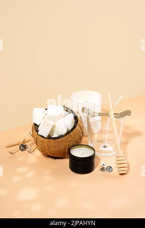 Kokosnusswachs, Kerze, Docht auf beige-rosa Hintergrund. Set für hausgemachte, natürliche, umweltfreundliche Kokosnusswachskerzen. Modernes handgefertigtes heimwerkerkonzept. Stockfoto