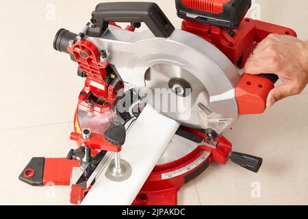 Schneiden von Sockelleisten mit einem professionellen Schneidwerkzeug Stockfoto