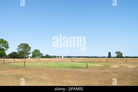 Golfplatz bedeckt mit trockenem Grasland mit grünem Gras über dem Loch von der Bewässerung während der Hitzewelle alles unter klarem blauen Himmel im Sommer in Beverley, Großbritannien. Stockfoto