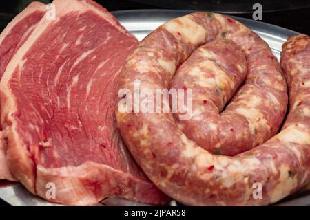 Rote rohe Steaks und Wurst, zum Grillen Stockfoto