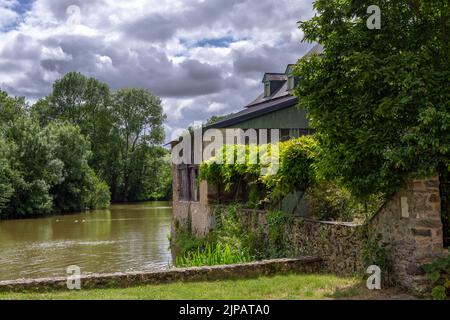 FRESNAY-SUR-SARTHE, FRANKREICH - 27.. MAI 2022: Walzwerk und Rindenmühle am Fluss Sarthe an einem wolkigen Frühlingsnachmittag Stockfoto