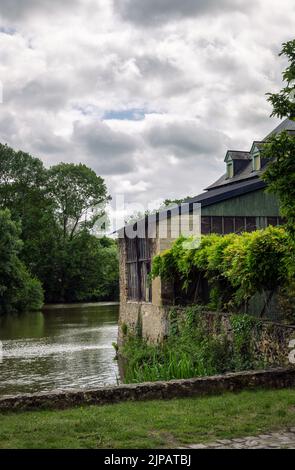 FRESNAY-SUR-SARTHE, FRANKREICH - 27.. MAI 2022: Walzwerk und Rindenmühle am Fluss Sarthe an einem wolkigen Frühlingsnachmittag Stockfoto