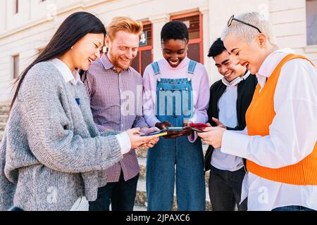 Eine Gruppe von Freunden, die Spaß mit Smartphones haben, die in sozialen Medien surfen. Stockfoto