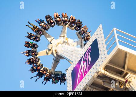 Junge Nervenkitzel-Suchende auf der Achse fahren in Adventure Island an einem heißen Sommertagabend in Southend on Sea, Essex, Großbritannien, während der Schulferien. Stockfoto