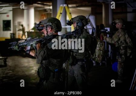 Die Bediener sichern den Raum nach einem Feuergefecht während einer Trainingsübung in Battle Creek, Michigan, 10. August 2022. Die Operation integrierte Wachmänner der 20. Special Forces Group (Airborne) mit Sitz in Birmingham, Alabama, mit lokalen, staatlichen und bundesstaatlichen Strafverfolgungsbehörden, um ein komplexes Gebäude zu infiltrieren, Feinde zu neutralisieren, Geiseln zu retten und gefährliches Material zurückzugewinnen. Die Veranstaltung war Teil von Northern Strike 22, einer gemeinsamen, multinationalen, alldomänenübergreifenden Kampfübung, die vom Camp Grayling Joint Maneuver Training Center aus veranstaltet wurde. (USA Foto der Armee-Nationalgarde von SPC. Cody Muzio Stockfoto