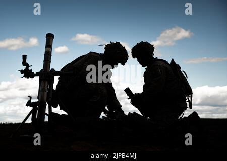 SPC der US-Armee. Brandon Almaguer, links, und U.S. Army SPC. Mattox Harrell, beide Infanteristen mit indirektem Feuer, die der Viper Company, 1. Bataillon, 26. Infanterie-Regiment, 2. Brigade Combat Team, 101. Airborne Division (Air Assault), zugewiesen wurden, reorganisiert nach Abschluss einer Feuermission zur Unterstützung des Manövers des Unternehmens während einer multinationalen Live-Fire-Übung im Trainingsgebiet Rovaniemi, Finnland, 11. August 2022. Die LFX war Teil der finnischen Sommerübung, bei der US-Truppen und finnische Truppen die Möglichkeit hatten, gemeinsam zu trainieren, um die Partnerschaft und Inter zu verstärken und zu stärken Stockfoto