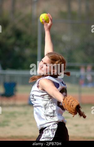 Jugend Mädchen Team und Trainer auf Sportplätzen während des Frühlings Sport, gecoacht und spielen Spiele Mädchen Softball Stockfoto