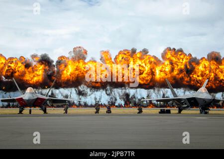 Kaneohe, Hawaii, USA. 13. August 2022. Während der Demonstration der Joint Air-Ground Task Force im Rahmen der Kaneohe Bay Air Show 2022, Marine Corps Air Station Kaneohe Bay, Marine Corps Base Hawaii, August, explodiert die Wall of Fire hinter zwei Raptoren der US Air Force F-22. 13, 2022. Die Flugshow bot die Gelegenheit, die Fähigkeiten einer gemeinsamen Truppe in der Indo-Pazifik-Region zu demonstrieren. Die Kaneohe Bay Air Show, die Luftaufführungen, statische Displays, Demonstrationen und Händler beinhaltete, wurde entwickelt, um die Wertschätzung von MCBH für die Bewohner von Hawaii und ihre fortgesetzte unterstützung auszudrücken Stockfoto