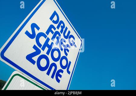 Drogenfreie Schulzone Zeichen über Drogen mit Kindern aufgrund von Landes- und Bundesgesetzen mit Textraum und Himmel für Kopie Stockfoto