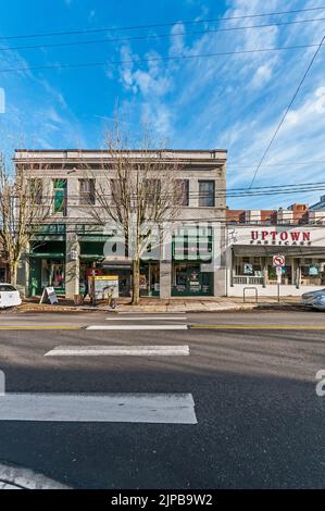 Der Mann entlädt ein pedalbetriebenes Lieferfahrzeug vor dem Uptown Billiards Club im Geschäftsviertel nahe 23. und Everett in Portland, Oregon. Stockfoto